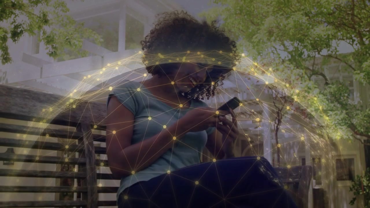 Woman tapping phone on bench, causing golden network globe expanding around her, showing technology