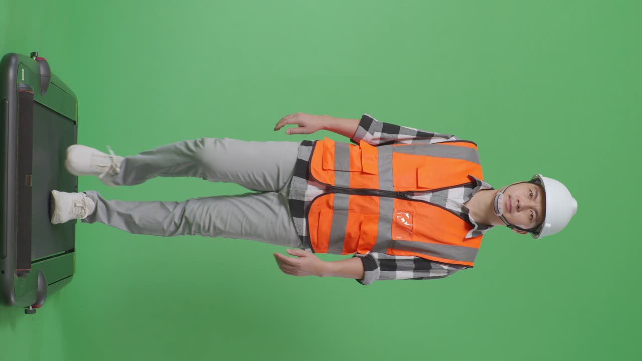 안전 헬을 입은 아시아 남성 엔지니어의 몸이 녹색 스크린 배경 스튜디오에서 고 있습니다.