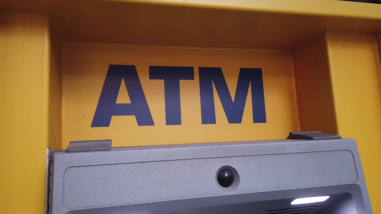 Primo piano ravvicinato a mano di un generico terminale bancomat.