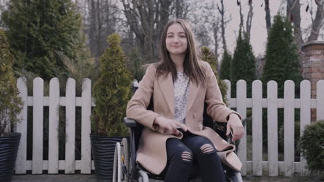 front view of a woman in wheelchair waving at camera