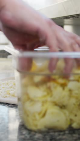 chef putting mozzarella on top of the raw pizza dough