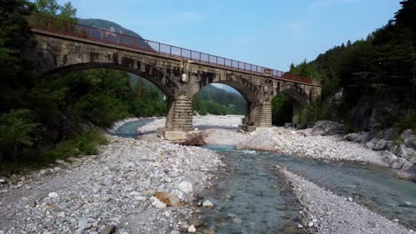 drone gracefully glides beneath the arches of an ancient railway bridge