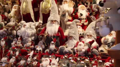 rows of santa clause figurines on a shop display at a festive christmas market in europe