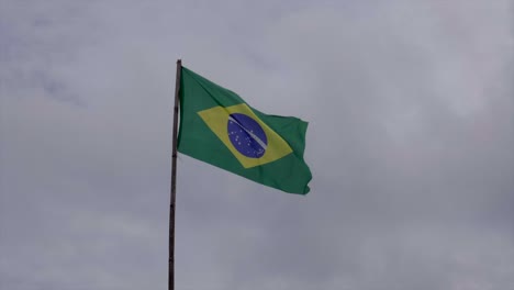 Brazil-flag-on-pole-waving-in-the-wind-on-overcast-cloudy-sky