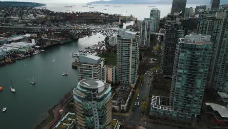 Disparo-De-Un-Dron-Que-Revela-El-Puente-De-La-Calle-Granville-Island-En-La-Ciudad-De-Vancouver-Y-El-Océano-Al-Fondo-En-Un-Día-Nublado,-Columbia-Británica,-Canadá