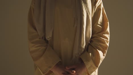 Close-Up-Of-Man-Wearing-Robes-Representing-Figure-Of-Jesus-Christ-With-Hands-Clasped-Together-1