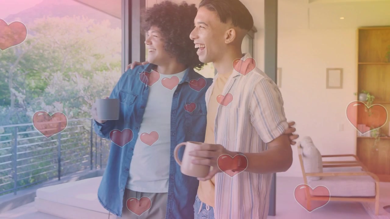 Man entering holding mug smiling causing heart overlay, partner hugging, both gazing balcony home