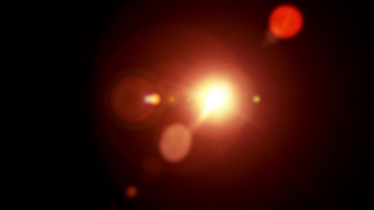Bright orange light with lens flare effect appearing on the left and disappearing on the right on black background, vertically centered. 4K Optical lens flares transition overlay effect seamless loop.