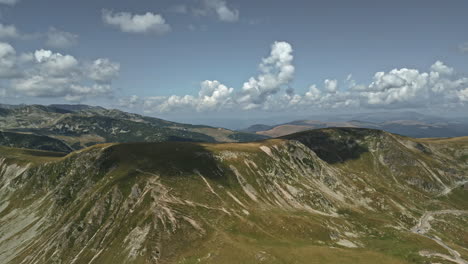 majestuosa vista de las montañas transalpinas en rumania, mostrando terrenos escarpados, caminos sinuosos y nubes dramáticas