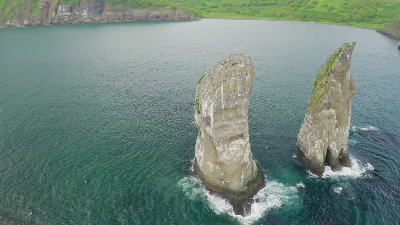 거대한 바위 타워, 티알 베이에서 바다 새들이 날아다니고 있습니다.