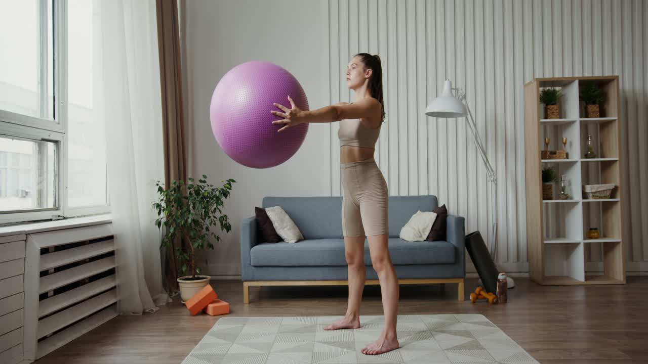 Woman doing squats with a ball