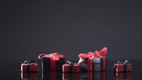 Video-of-gift-boxes-with-red-and-black-ribbons-and-copy-space-over-black-background