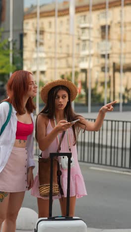 two women exploring a city with a suitcase