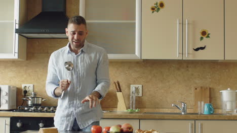 man singing in the kitchen with a ladle