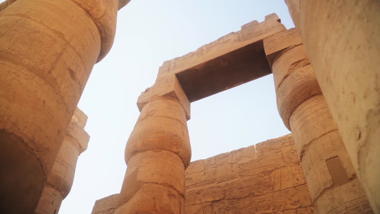 Low angle shot of tall Karnak Temple pillars. Slow sideways camera slide and rotation