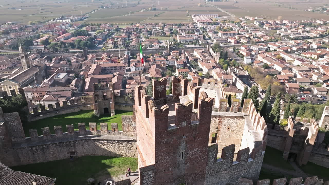 imponente torre del castillo del siglo xiv con bandera italiana en la ciudad de soave, verona, italia