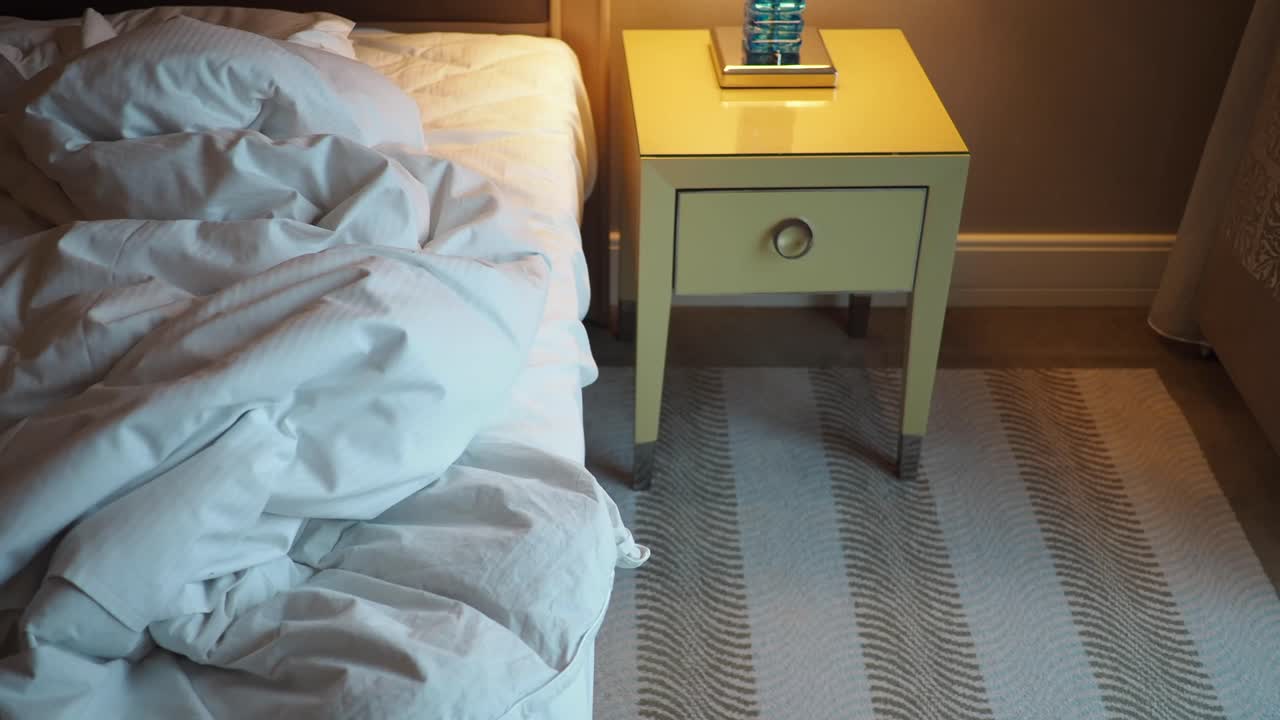 Ranjang Berantakan dan Meja Nakas di Kamar Tidur yang Nyaman