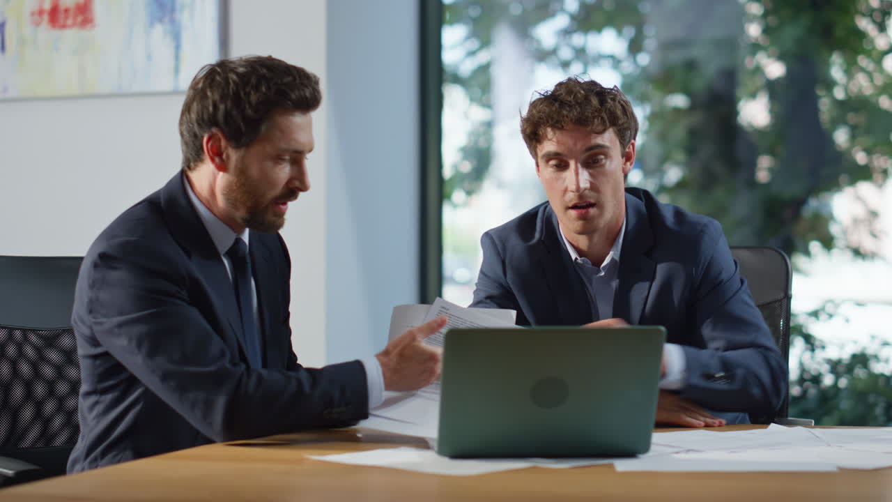 Colleagues video calling laptop workspace closeup. Positive businessmen greeting