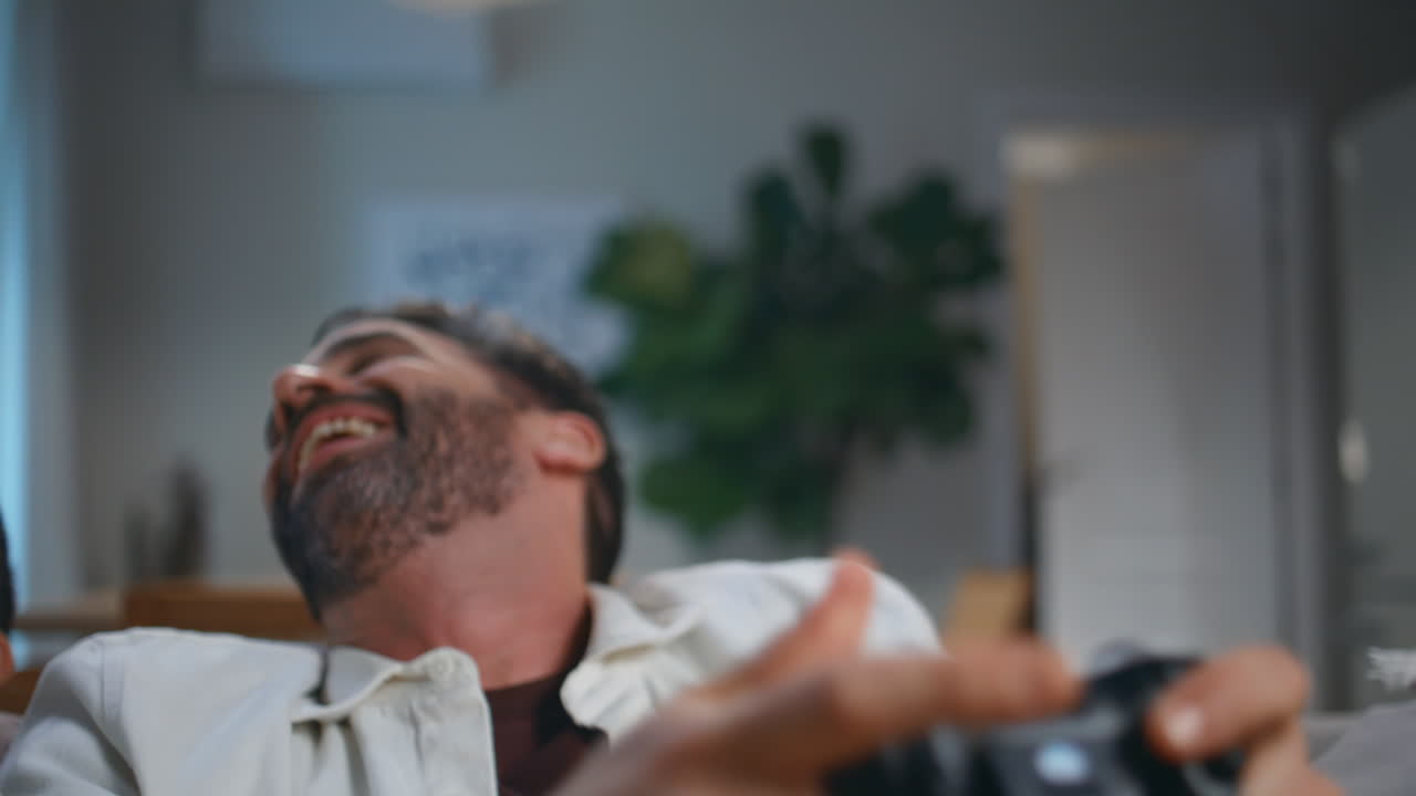 Excited gamer holding joystick for computer videogame at evening house closeup