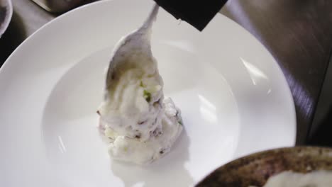 chef pouring food into plate