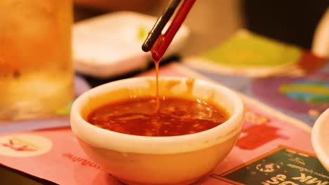 chopsticks interacting with sauce in bangkok restaurant