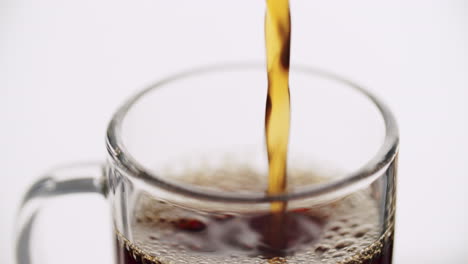 studio shot -- glass getting filled with coffee-tea