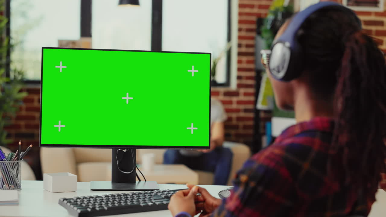 Female student with headset looking at greenscreen display