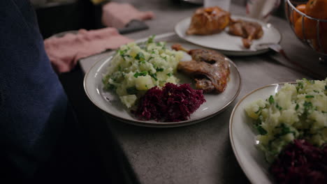 Close-up-shot-of-a-woman-using-chopsticks-to-place-red-cabbage-on-the-plate,-food-presentation,-plating-techniques,-festive-food,-roasted-duck-leg,-crushed-potato,-parsley,-delicious-dinner,-cooking