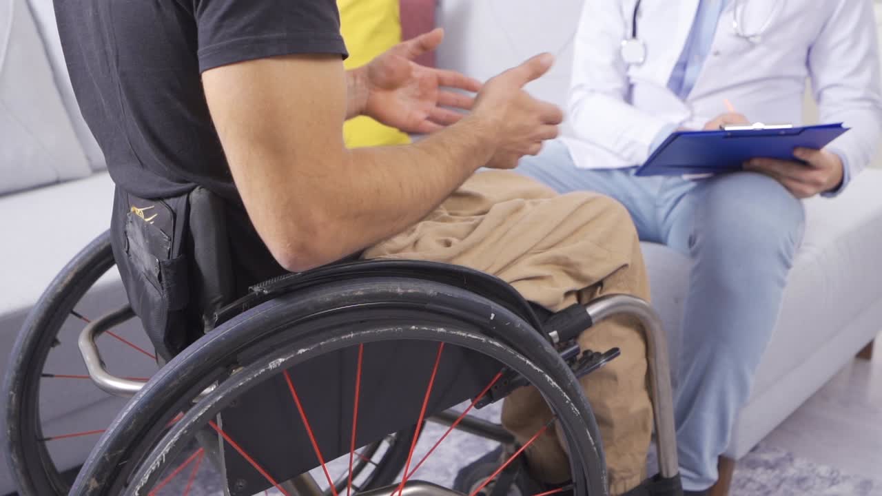 장애인 남자가 천천히 의사와 얘기하고 있습니다.