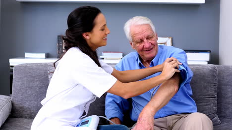enfermera en el hogar comprobando la presión arterial de sus pacientes