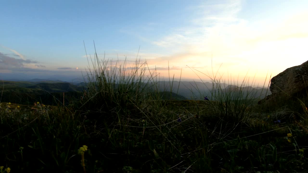 puesta de sol en la montaña sobre la roca pico. clave oscura puesta de sol luz en las montañas paralaje rocas hierba de roca