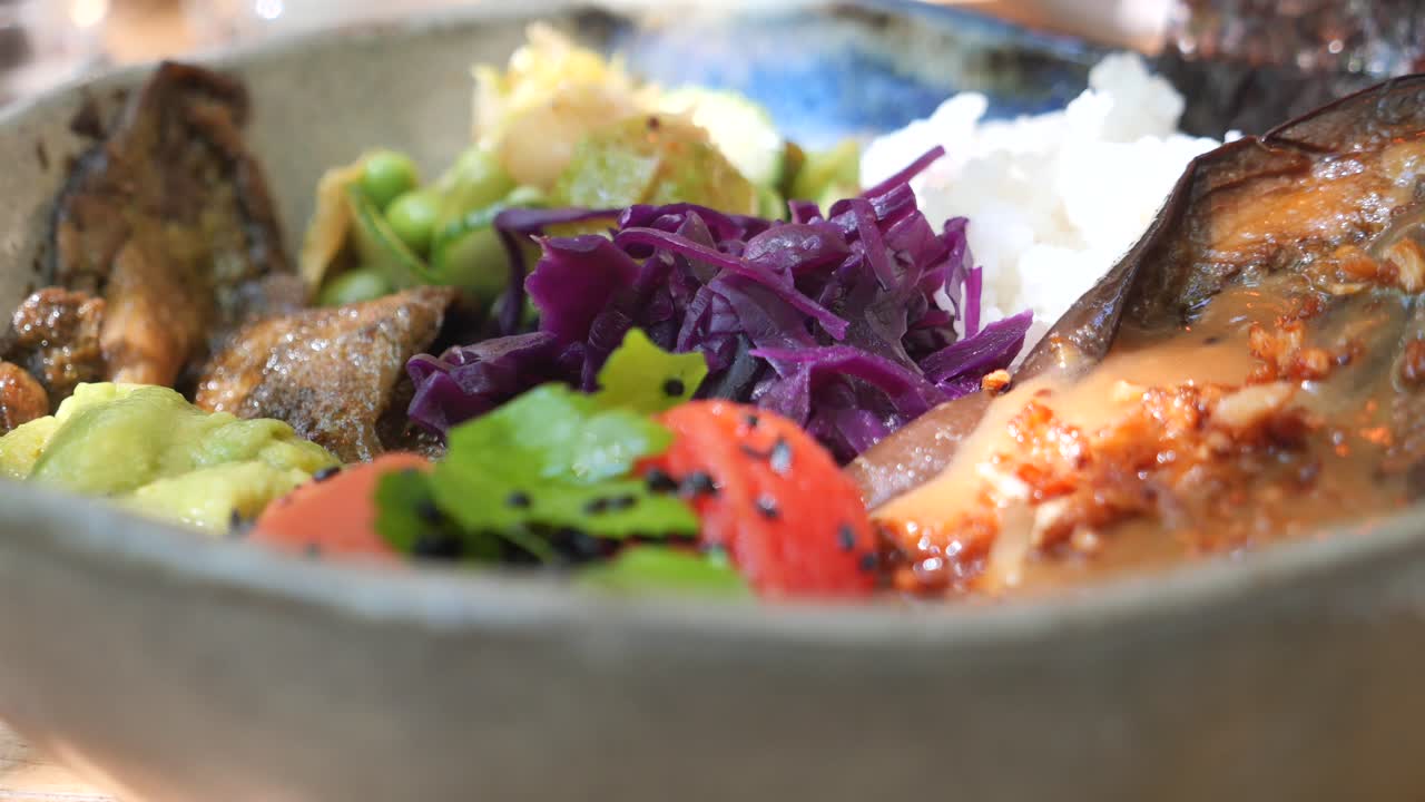 Bowl of food with rice, eggplant and vegetables