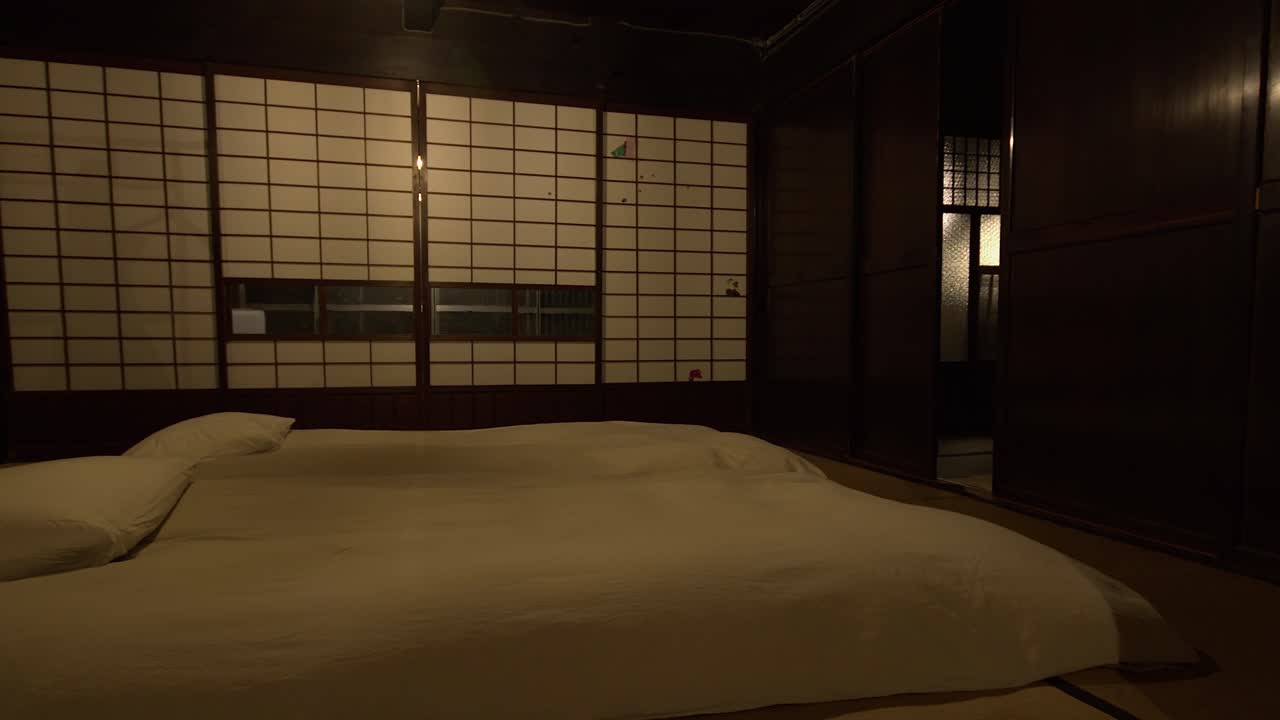 Bois foncé dans une chambre japonaise traditionnelle avec des futons et des portes shoji