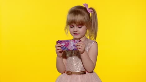 niña usando un teléfono inteligente. niño enviando mensajes de texto en el teléfono electrónico. niño jugando juegos en el teléfono móvil en el estudio