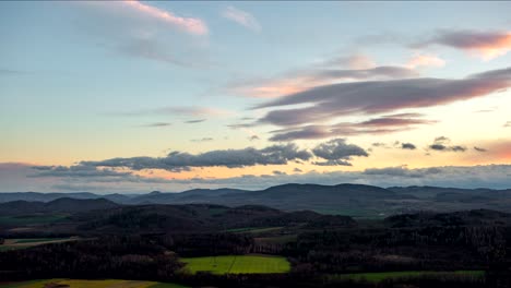 time lapse of a lenticular cloud formation, during sunset, over a mountain landscape