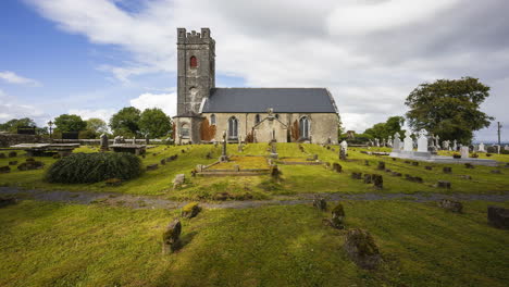 lapso de tiempo del cementerio histórico y la iglesia medieval en la irlanda rural con nubes pasajeras y sol