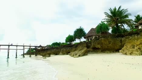 bungalow-on-a-rock-surrounded-by-coconut-trees-in-a-white-sand-beach-in-zanzibar