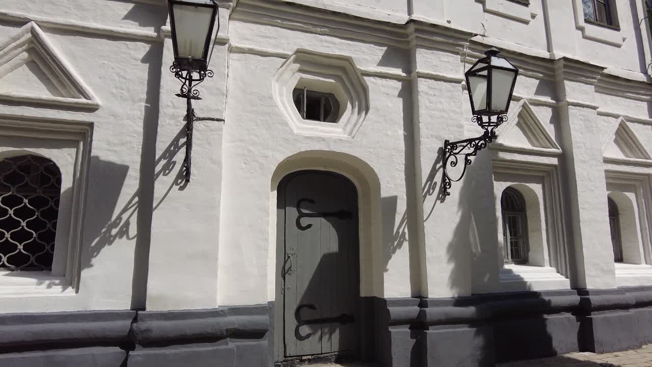 el monasterio: pared blanca, puerta, ventana y cielo azul.