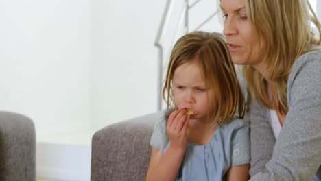 Madre-E-Hija-Comiendo-Patatas-Fritas-En-El-Sofá-4k