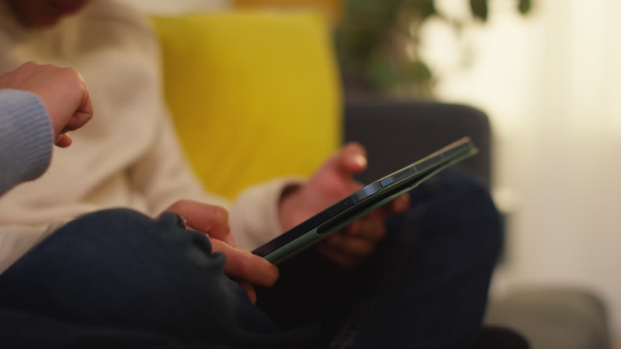 집에서 소파에 앉아서 게임을 하거나 디지털 태블릿 8에 스트리밍하는 두 어린 소년