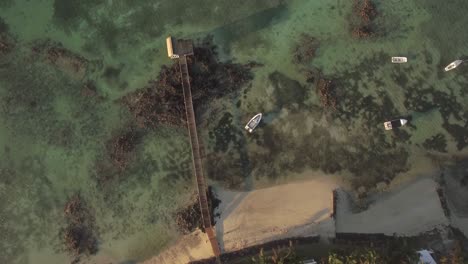 Resort-coast-wooden-pier-and-boats-in-ocean-Aerial-view