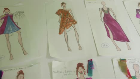 detail of a fashion designer's workstation with drawings and sketches of her last collection