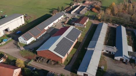 Paneles-Fotovoltaicos-Montados-En-El-Techo-De-La-Granja-Que-Utiliza-Energía-Verde-Y-Limpia-Que-Producen,-Vista-Aérea