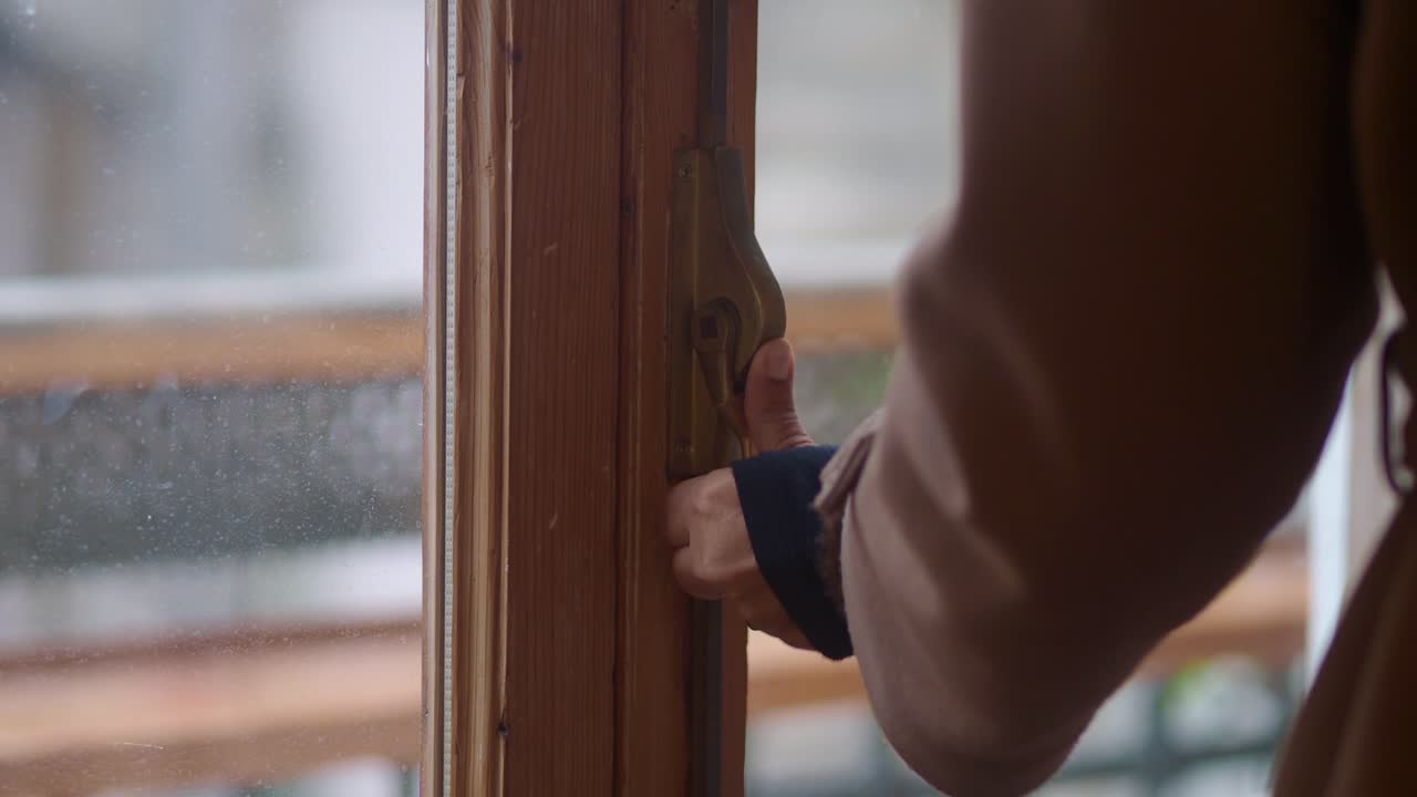 Close Up of Hand Closing a Wooden Window Latch