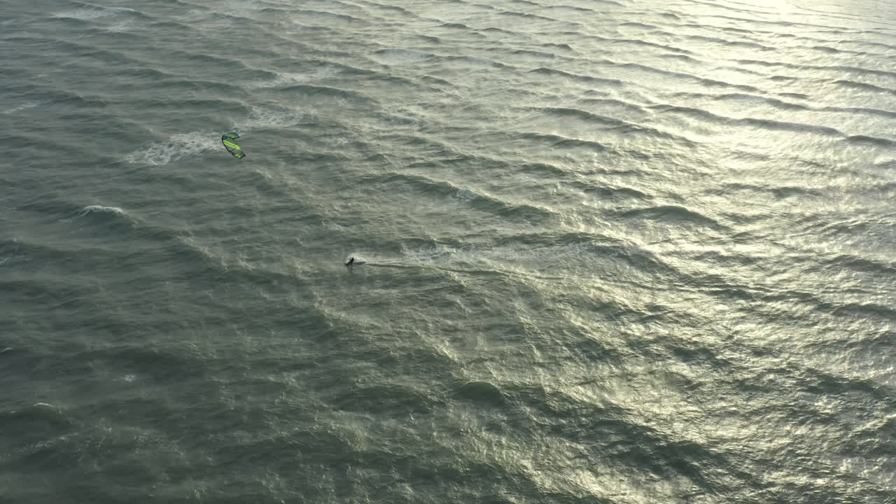 surfista de cometas cerca de la playa, montando el viento con su cometa, imágenes de drones