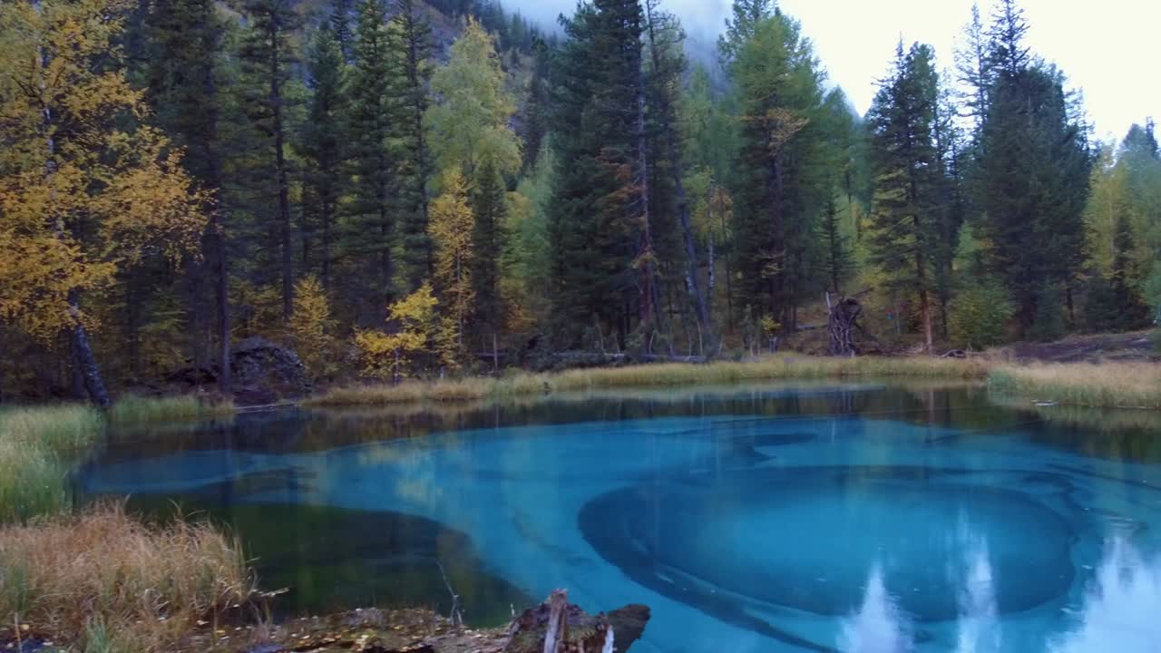 Panorama del lago Blue Geyser sui monti Altai in una giornata piovosa