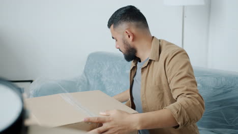 man unpacking boxes at home