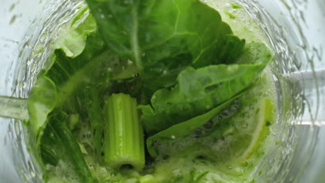 closeup greens blending mixer in super slow motion. preparing vegetarian food.