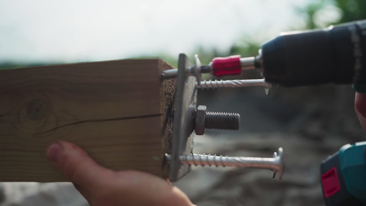 무선 스크루드라이버 드릴을 사용하여 나무 기둥과 금속 판에 나사를 고정