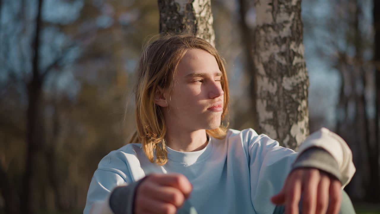 Молодые люди наслаждаются спокойной лесной обстановкой, умиротворяющая природа с созерцательной молодежью в лесу, тихий природный ландшафт со спокойной молодежью, погруженной в солнечный свет рядом с деревьями